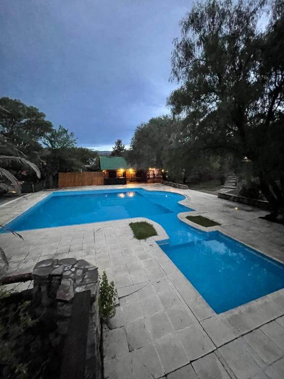 una piscina de agua azul en un patio en complejo urquiza departamentos en Mina Clavero