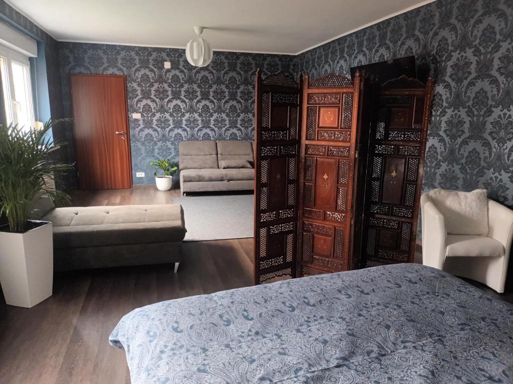 1 dormitorio con 1 cama y sala de estar con sofá en The Cottage en Murska Sobota