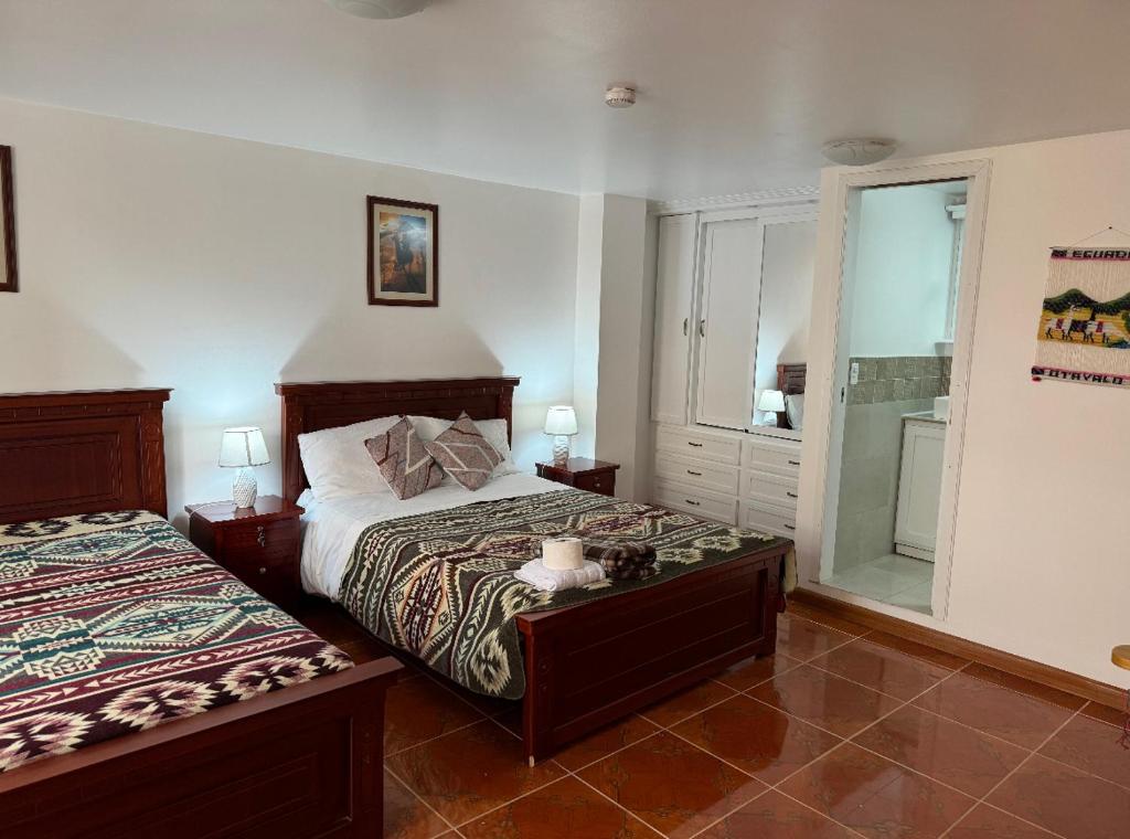 1 dormitorio con 2 camas y ventana en Kimsa Wasi III en Otavalo