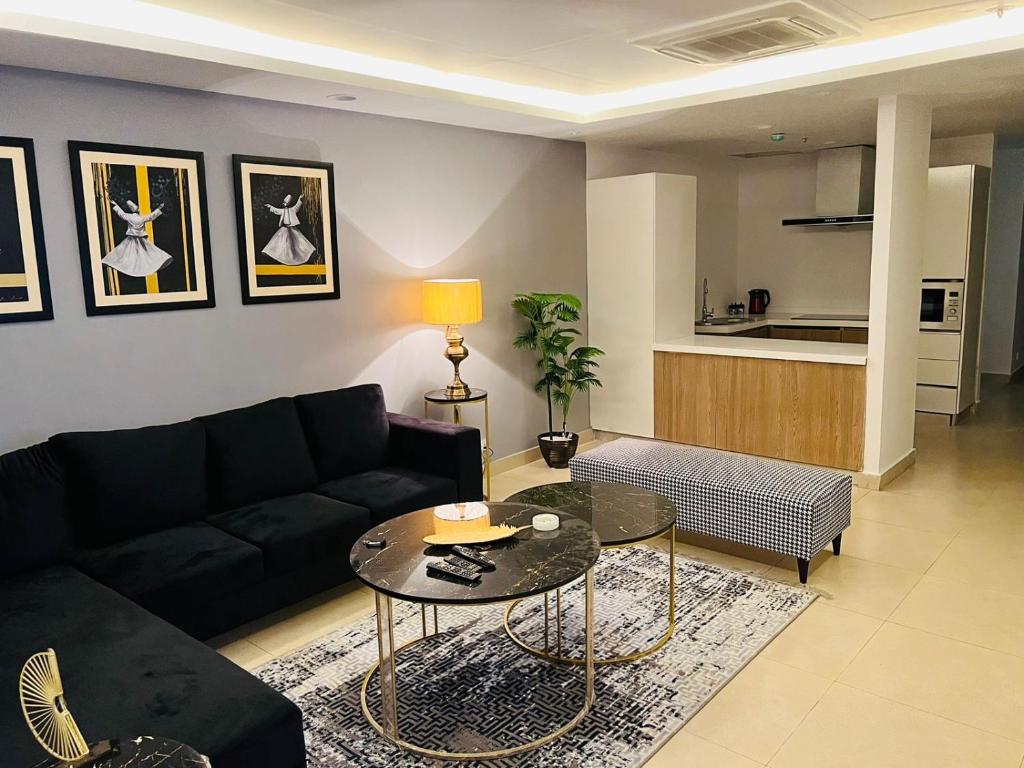 - un salon avec un canapé noir et une table dans l'établissement One Bed Luxury Apartment, à Lahore