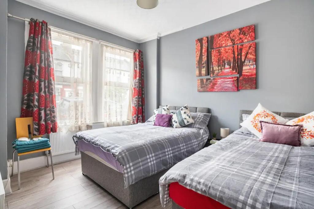 um quarto com 2 camas e uma janela em Hatton Homes - Thackeray Avenue em Londres