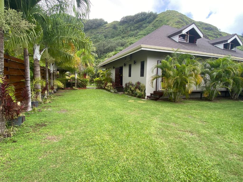 a house with a lawn in front of it at Villa Ora Na in Mahina