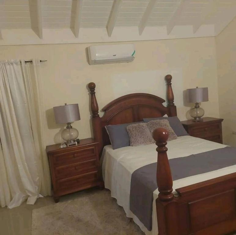 a bedroom with a bed and two night stands with lamps at Royal Palms Luxury Villas in Ocho Rios