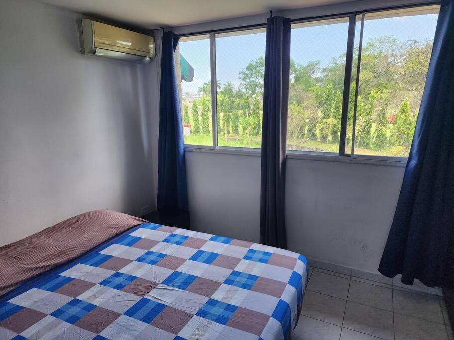 a bedroom with a bed and two windows at Acogedor Apartamento Completo 2 Recamaras 2 Baños. in Panama City