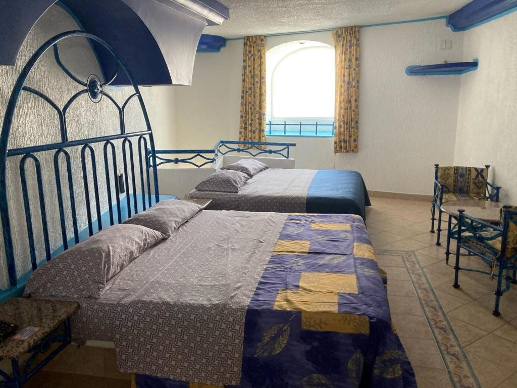 sypialnia z 2 łóżkami i oknem w obiekcie Hotel Oasis Acapulco w Acapulco