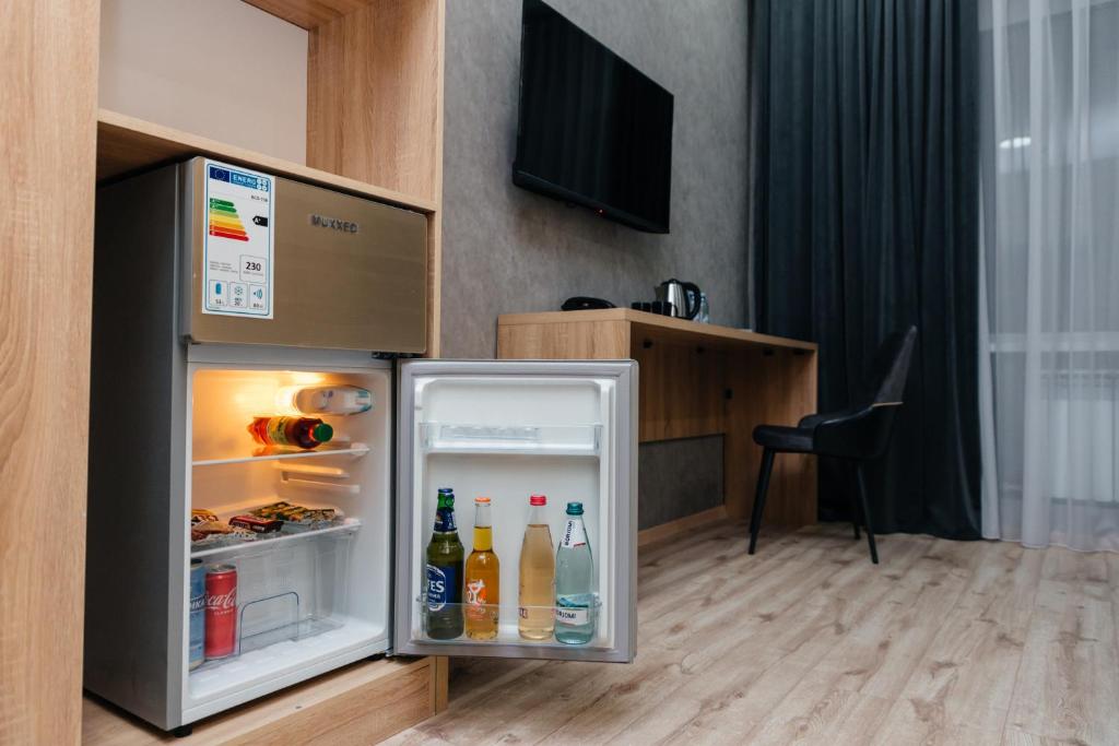 einen offenen Kühlschrank mit Getränken darin in der Unterkunft Sunrise Hotel in Taldyqorghan