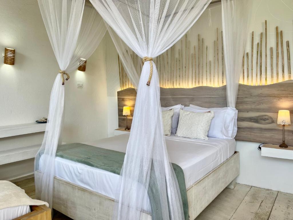 a bedroom with a canopy bed with white drapes at Casa Kai in Palomino