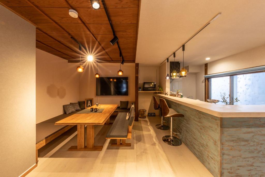a kitchen with a wooden table and a counter at HIDA TAKAYAMA BASE - Traditional Japanese Garage House with Private Sauna in Takayama