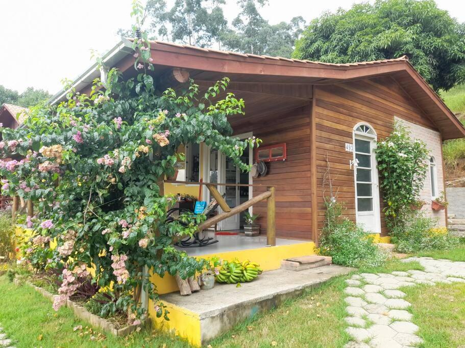 uma pequena casa de madeira com um ramo de flores em Casa da Montanha: Minha Casa, tua Casa! em Gravatal