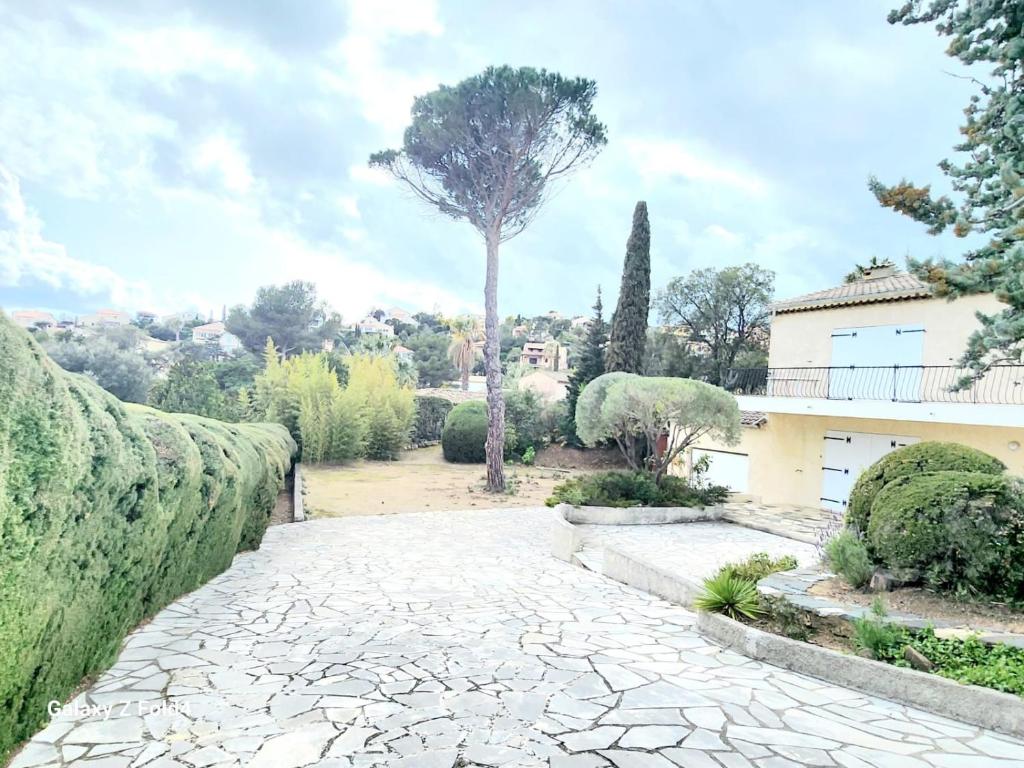 une passerelle en pierre devant une maison avec un arbre dans l'établissement Villa La Chenal, à Fréjus