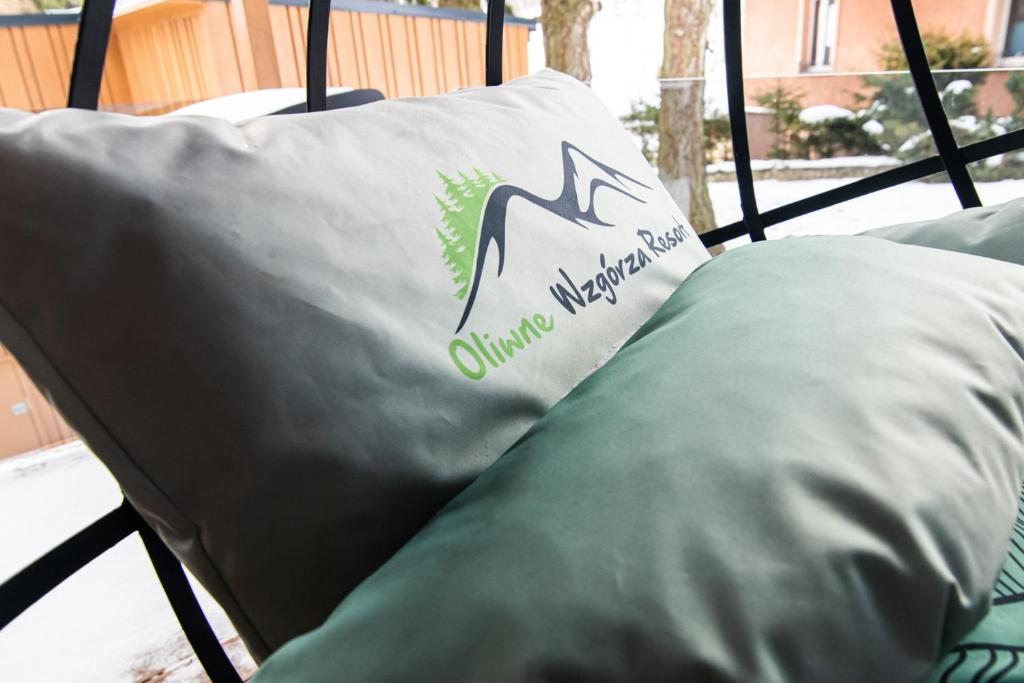 a bed with a pillow with a comforter on it at Oliwne Wzgórza in Stronie Śląskie