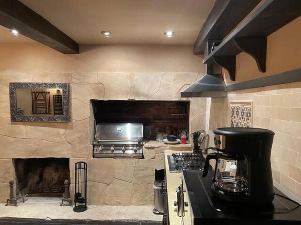 a kitchen with a stone wall with a stove at Junior Suite in Los Gatos