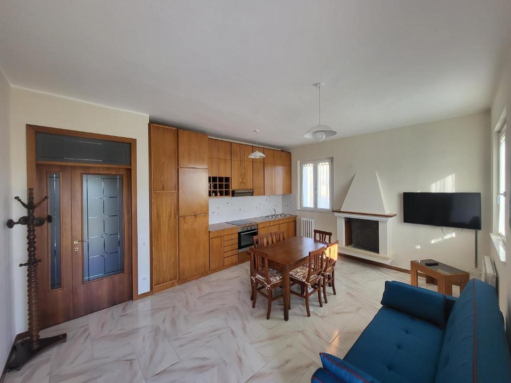 une cuisine et une salle à manger avec une table et un canapé bleu dans l'établissement Appartamento - Porto San Giorgio, à Porto San Giorgio