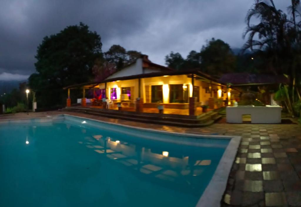 a villa with a swimming pool in front of a house at CQ SANTA ANA in San Antonio del Tequendama