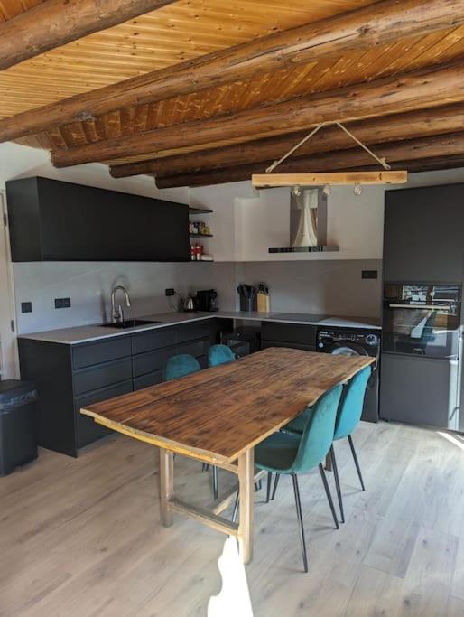 une cuisine avec une table en bois et des chaises bleues dans l'établissement Appartement rénové proche centre ville navette 6-8 personnes multipass, à Châtel