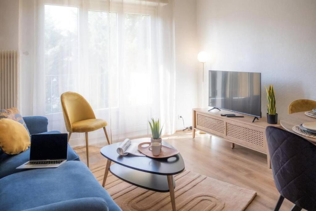 La Robertsau, Lumineux, Paisible في ستراسبورغ: غرفة معيشة مع أريكة زرقاء وتلفزيون