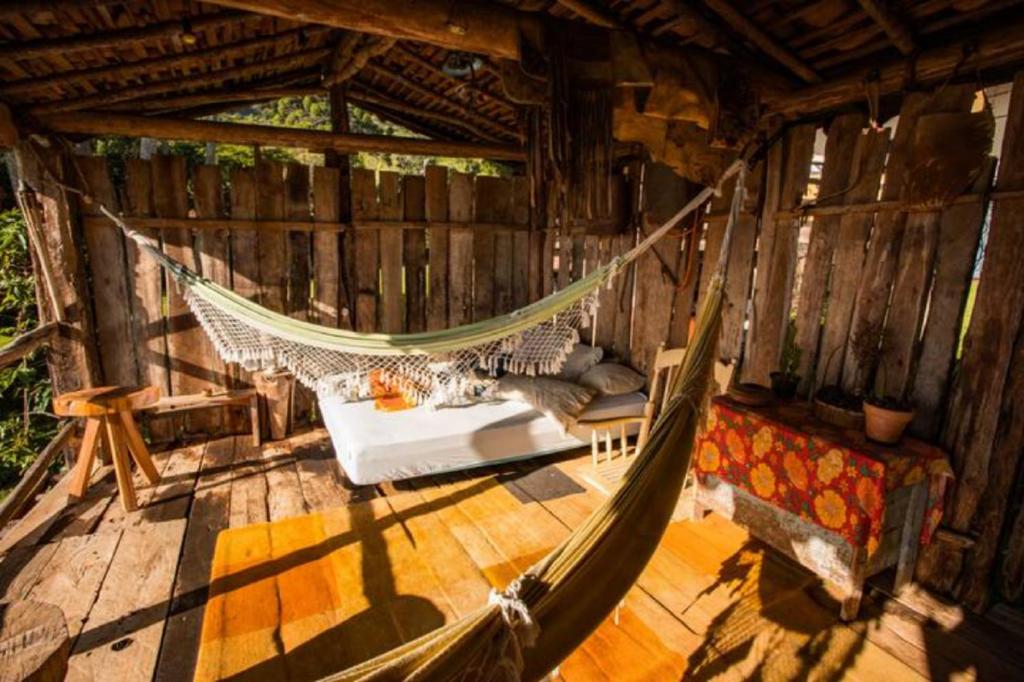 a hammock in the middle of a wooden cabin at Hospedaria Vida na Roça in São Bento do Sapucaí