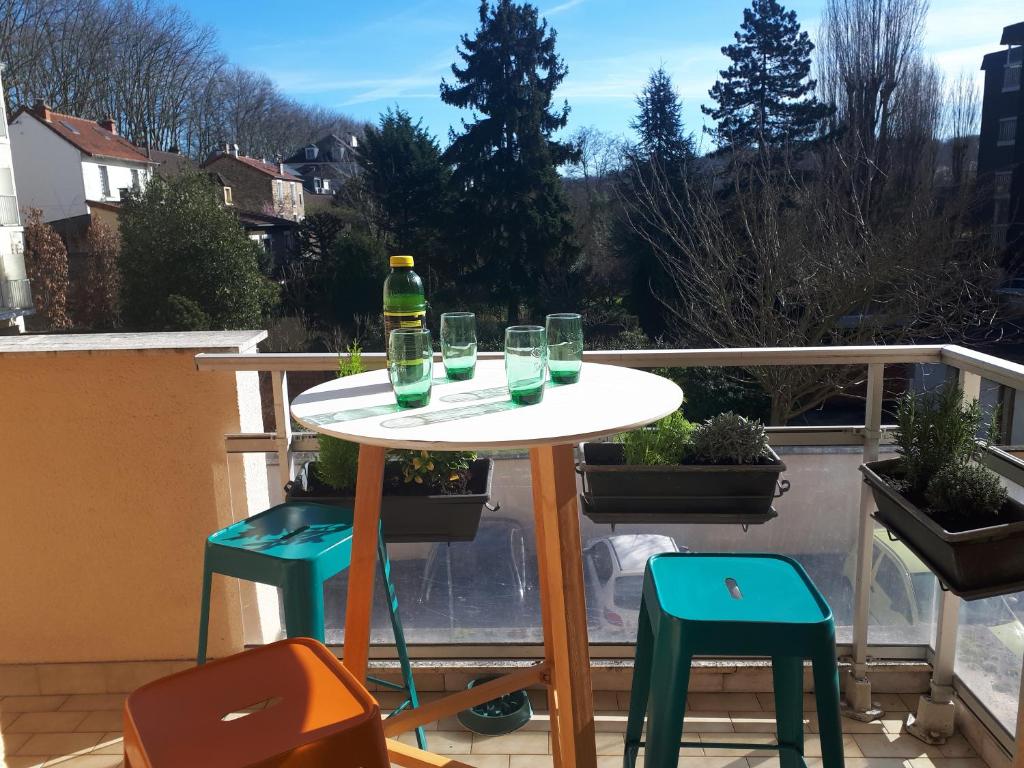 une table avec des verres et une bouteille sur un balcon dans l'établissement Appartement 3 chambres 5 couchages, à Versailles
