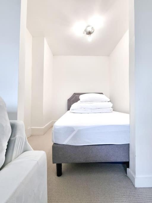 a white room with a bed and a couch at Fresh and Sparkling - Free Parking in Crystal Palace
