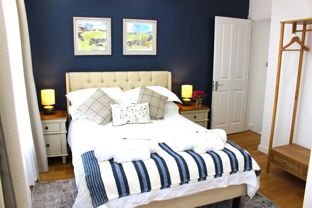 Schlafzimmer mit einem Bett mit blauer Wand in der Unterkunft Elegant 4 bedroom, Maidstone house by Light Living Serviced Accommodation in Maidstone