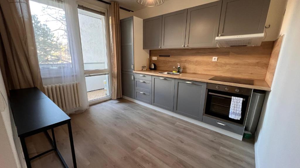 a kitchen with gray cabinets and a counter top at Air conditioned 3 room apartment, near Technopol in Bratislava