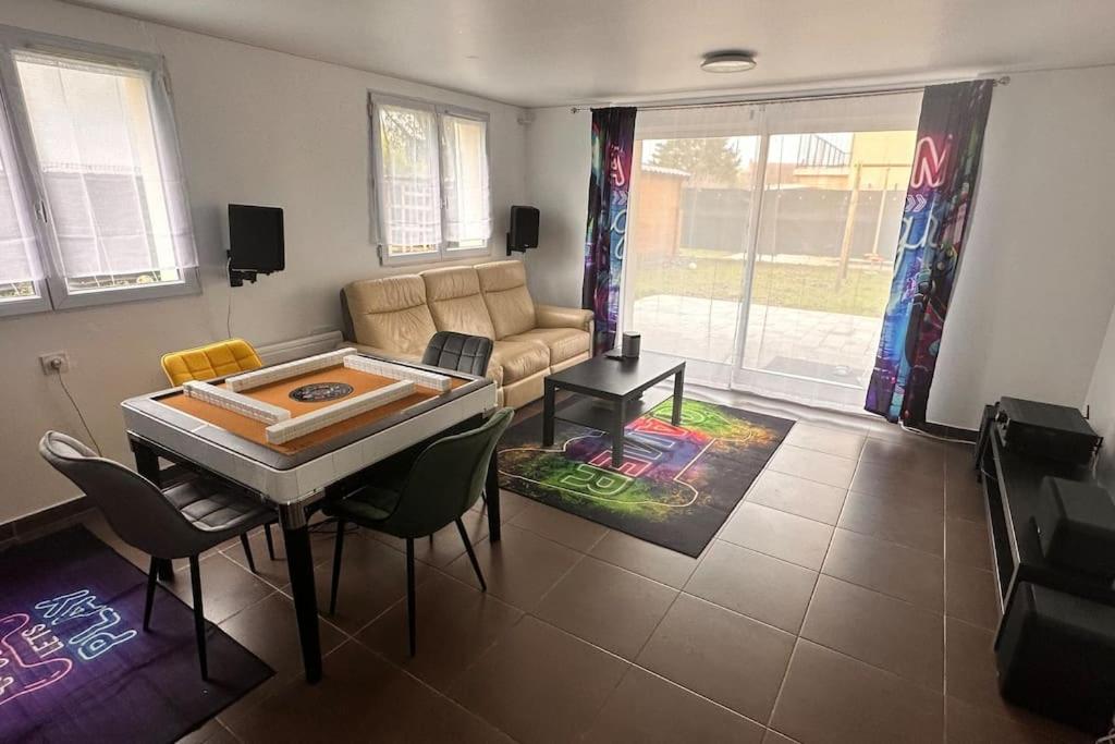 un salon avec un canapé, une table et des chaises dans l'établissement Bel appartement proche Paris et Disney, à Sucy-en-Brie