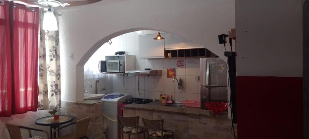 a kitchen with an archway and a table in a room at Apartamento Tá Querendo Praia! in Guarujá