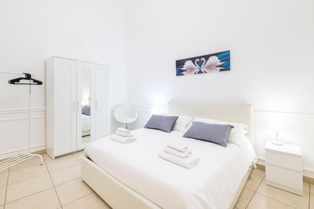 ナポリにあるMontesanto Homeの白いベッドルーム(白いベッド1台、鏡付)