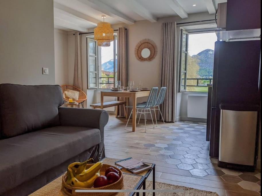 uma sala de estar com um sofá e uma mesa em La Perle du Lac 3* - VUE LAC em Annecy