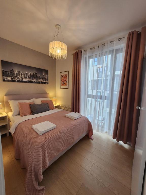 a bedroom with a bed and a large window at Premium Spire Apartment +parking in Warsaw