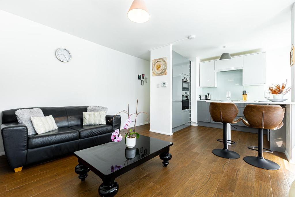 sala de estar con sofá negro y mesa en Charming 1 Bedroom Serviced Apartment in Camden, en Londres