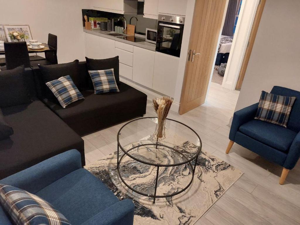 a living room with a couch and a table at Two-Bedroom apartment with free Parking in Upholland