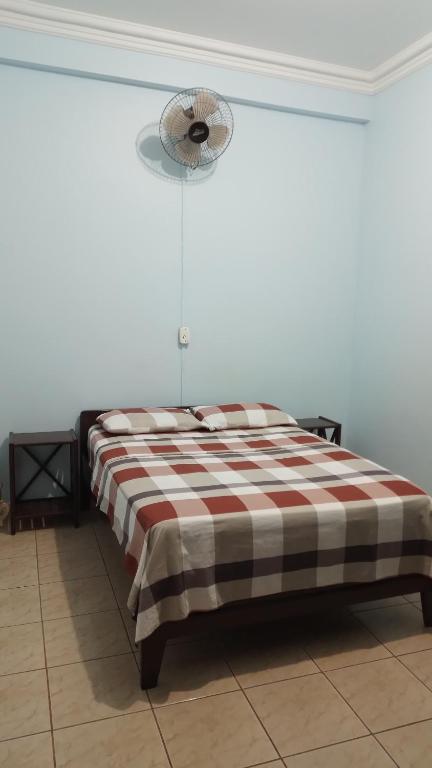 a bed with a checkered blanket in a room at Alojamiento Oruro in Riberalta