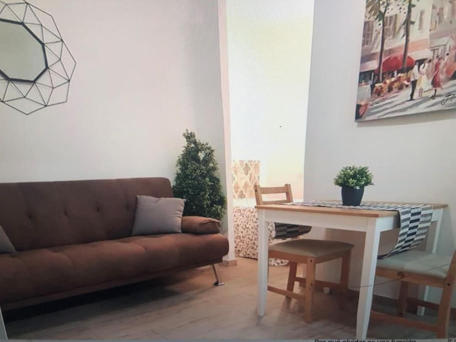 a living room with a couch and a table at Sebastian Elcano, apartamento para 2 con terraza, metro Embajadores in Madrid