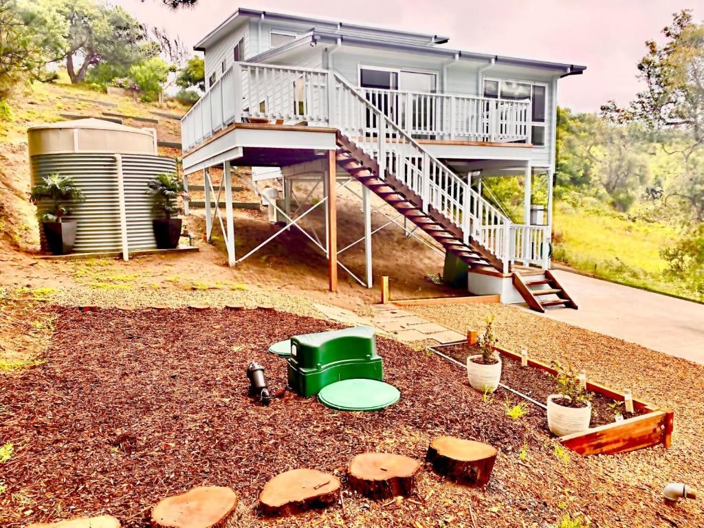 een huis met een balkon en een tuin met champignons bij Elevate Escape in Venus Bay