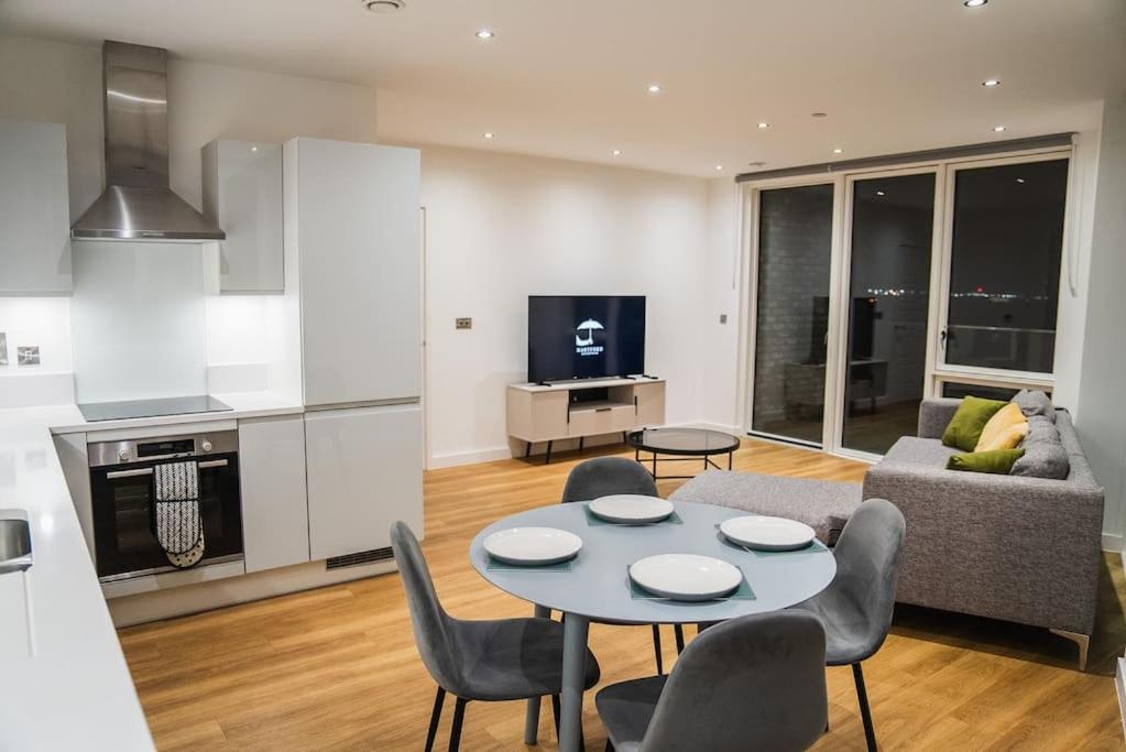 a kitchen and a living room with a table and chairs at Top floor Apartment in London