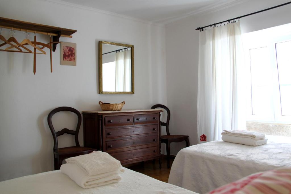 1 dormitorio con 2 camas, tocador y espejo en Casa Toníca, en Crato