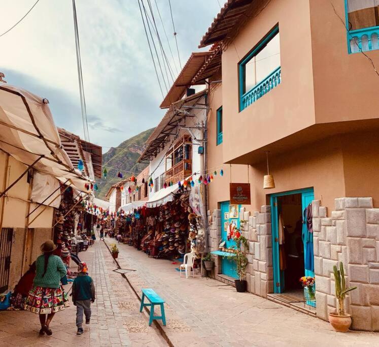 a couple of people walking down a street with buildings at Departamento acogedor céntrico in Cusco