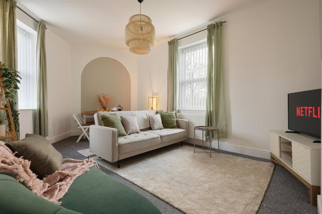 Luxury Sheffield Apartment - Your Ideal Home Away From Home في Stannington: غرفة معيشة مع أريكة وطاولة