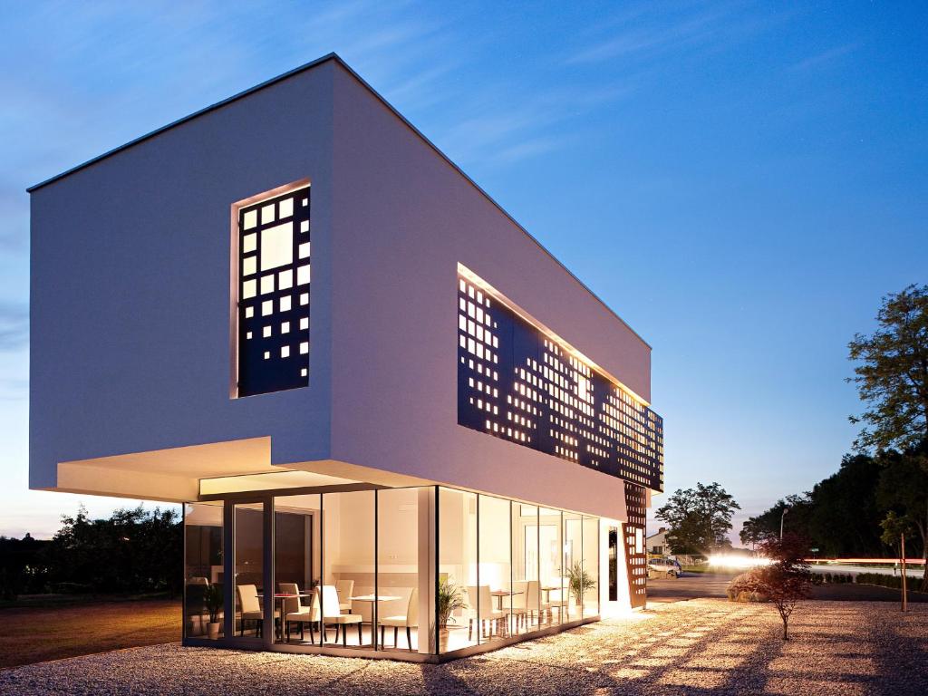 a large building with chairs outside of it at Hotel Caldor - 24h self-check in in Münchendorf