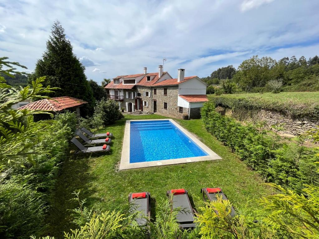 a house with a swimming pool in the yard at La coruña Sas playa y golf in Paderne