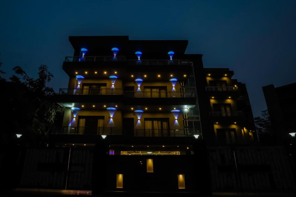 um edifício com luzes azuis no topo à noite em Super Townhouse 1291 Akshay Hotel em Gurgaon