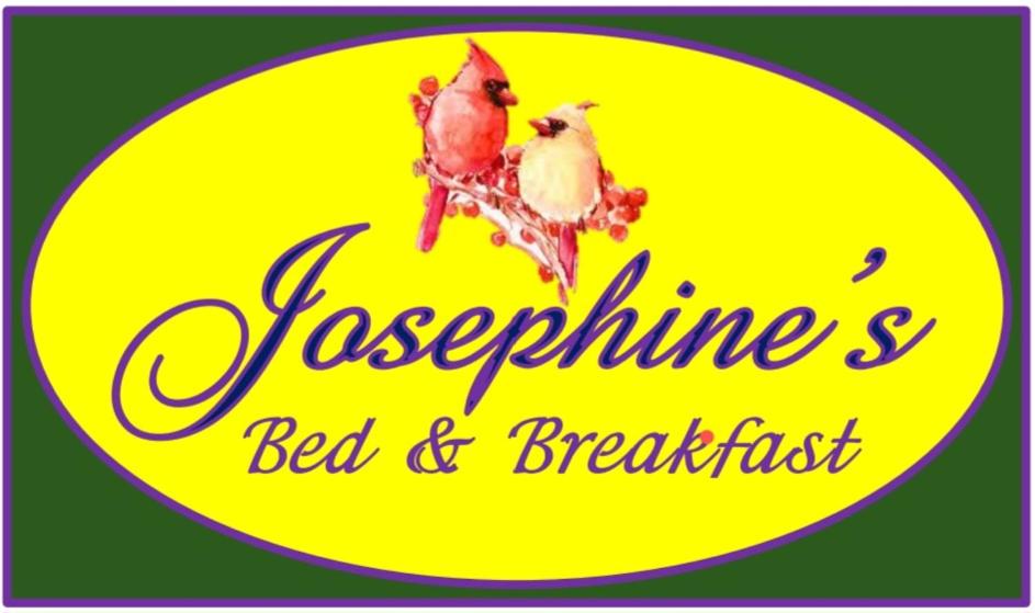 Dois pássaros sentados num poleiro com um sinal amarelo em Josephine's Bed & Breakfast em Titusville