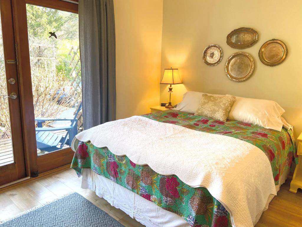 a bedroom with a bed and a sliding glass door at Wisteria Guest House in Ganges