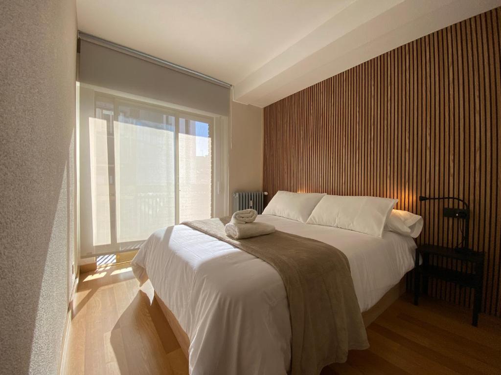 1 dormitorio con cama y ventana grande en Boutique Valbuena by ARoom - Centro con plaza de garaje, en León