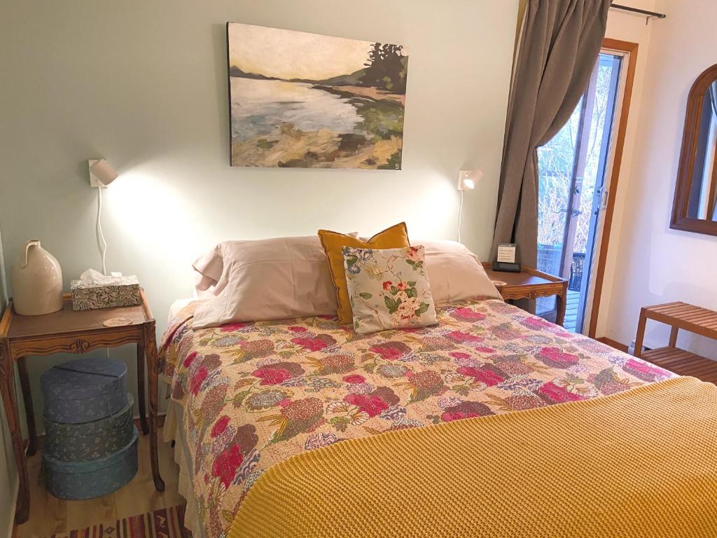 a bedroom with a bed with a quilt on it at Wisteria Guest House in Ganges