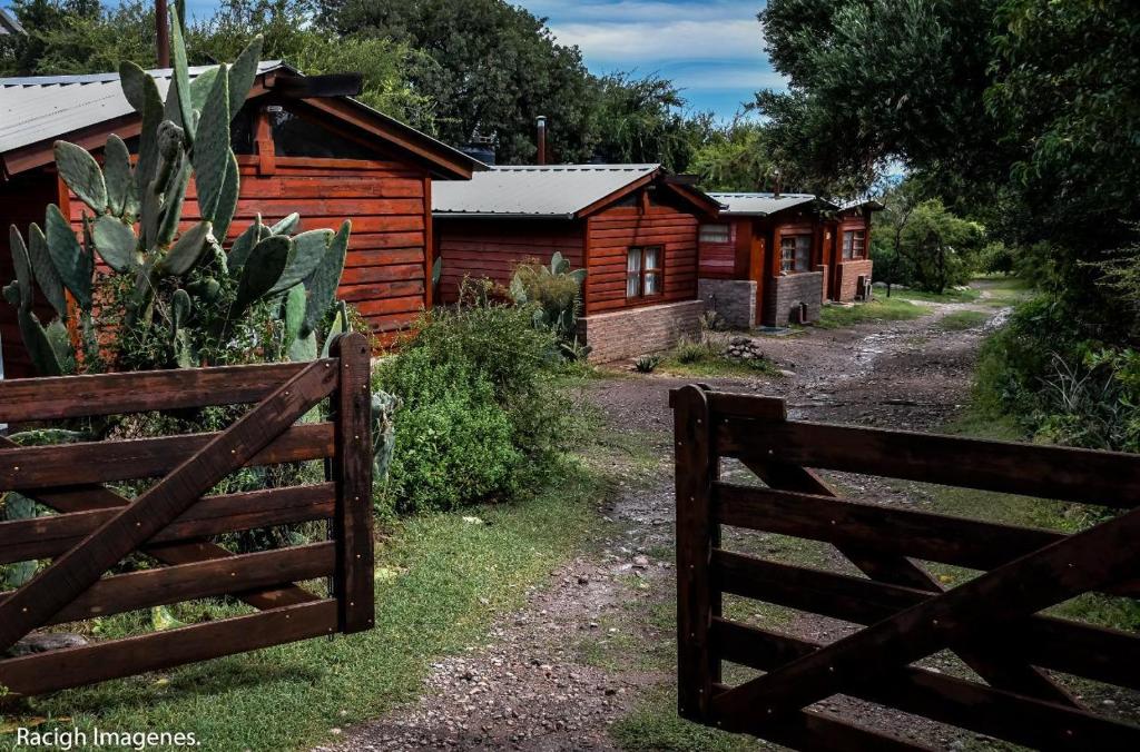 einen Zaun vor einer Reihe von Häusern in der Unterkunft El Colibrí - Quebrada de la Luna. in Charbonier