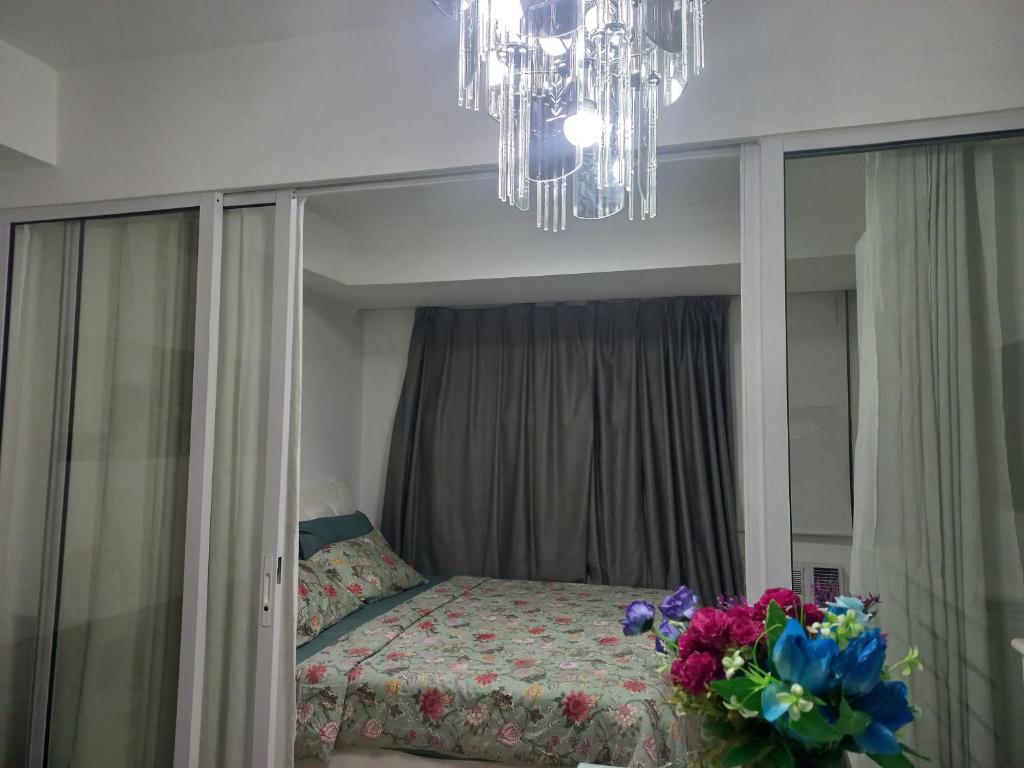a bedroom with a bed with a mirror and a chandelier at Azure Urban Resort Staycation By Owner Only in Manila