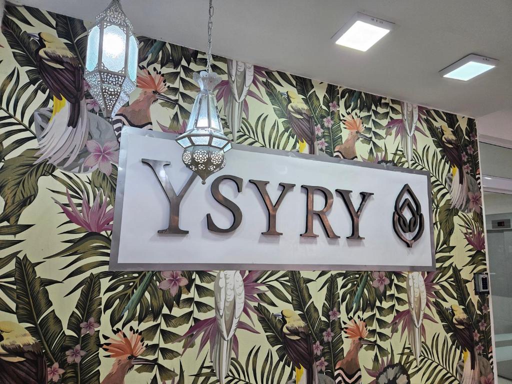 een teken dat zegt xy op een muur met bloemen bij YSYRY PISO 4, BONITO Y MODERNO DEPTO. EN BARRIO VILLA SARITA in Posadas