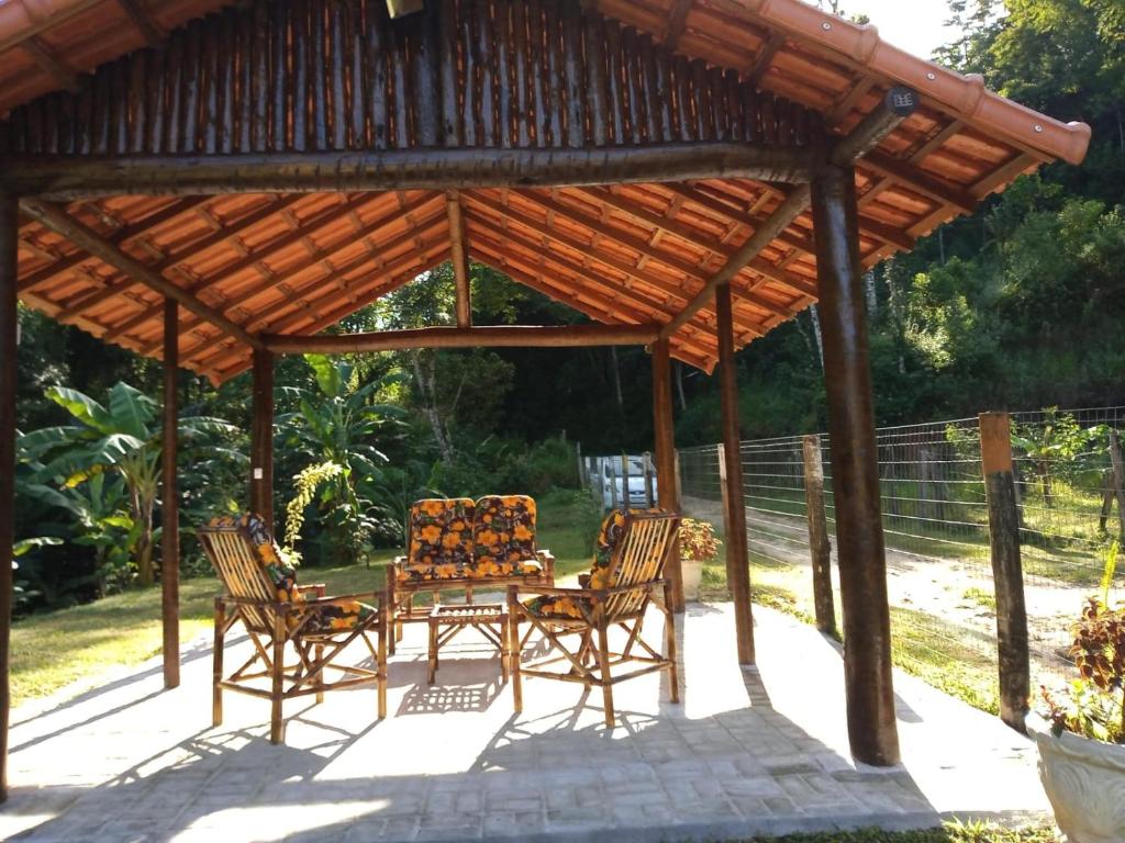 a wooden gazebo with a table and chairs at Casa da Lu in Macaé